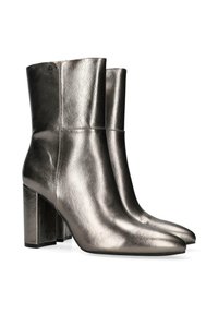 Metaliczne srebrne botki do kostek o gładkiej fakturze, z wydłużonymi noskami i kwadratowymi wysokimi obcasami. Prosty design z detalami w postaci przeszyć.