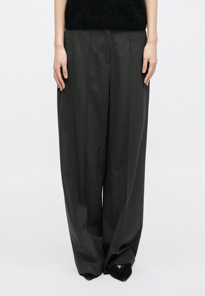 Παντελόνια με φαρδύ μπατζάκι σε σκούρο γκρι με διακριτικές ρίγες. Κατασκευασμένα από απαλό ύφασμα, με εφαρμογή που αγκαλιάζει το σώμα και καθαρή μέση.