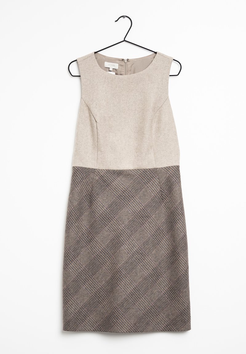 Robe sans manches longueur genou avec haut beige et jupe à motif écossais marron, suspendue sur un cintre noir sur fond blanc.