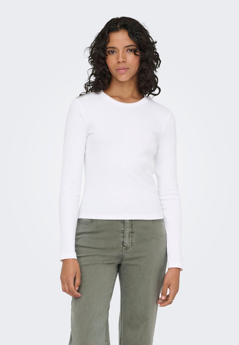 Λευκό εφαρμοστό μακρυμάνικο μπλουζάκι με στρογγυλή λαιμόκοψη και ριπ υφή, σε συνδυασμό με χακί χαλαρά παντελόνια.