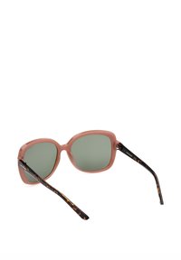 Gafas de sol de plástico rosa con lentes verdes, de forma redondeada, brazos con patrón de carey y un sutil detalle en el herraje.