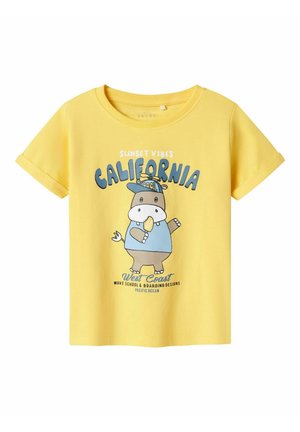 Camiseta de algodón amarilla con un gráfico de un animal de dibujos animados sosteniendo un helado, con el texto "California" y "Sunset Vibes" en azul y negro.