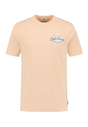 Camiseta de algodón color durazno con mangas cortas, cuello redondo y texto azul que dice "Club Locale" junto con un diseño gráfico.