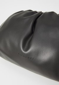 Czarna skórzana torba o miękkim, marszczonym wzorze. Posiada subtelne logo wytłoczone z jednej strony. Gładka tekstura i zaokrąglony kształt.