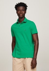 Groene poloshirt van katoen, met een klassieke kraag, twee knopen, korte mouwen en een klein logo op de linkerborst.