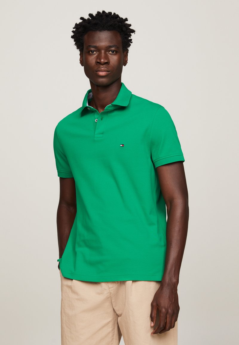 Groene poloshirt van katoen, met een klassieke kraag, twee knopen, korte mouwen en een klein logo op de linkerborst.