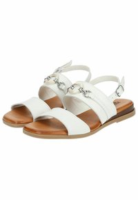 Sandali bianchi con più cinturini, caratterizzati da un accento metallico e una suola marrone. Texture liscia con design aperto per una migliore traspirabilità.