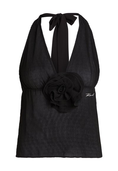 Haut noir sans manches style dos-nu avec tissu texturé, grande décoration fleur en tissu à la taille et fermeture à nouer au cou.