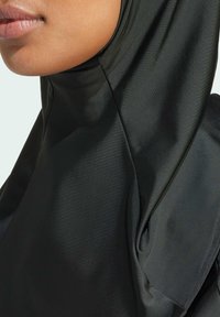 Crni hijab od tkanine s glatkom, sjajnom teksturom. Dizajn sadrži drapirane nabore i usko pristajanje oko lica i vrata.