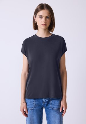 Maglietta grigio scuro a maniche corte con scollo rotondo. Tessuto liscio con vestibilità comoda, abbinata a jeans in denim blu chiaro.