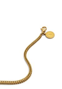 Kultaketjuinen kultaketju rannekoru, jossa on lukkona rapu sekä pyöreä charm, johon on kaiverrettu tyylitelty äärettömyyssymboli valkoista taustaa vasten.