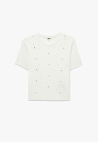 Hvid strikket kortærmet t-shirt med ribbet tekstur og spredte perle-finish, der minder om små blomster. Rund halsudskæring, afslappet pasform.