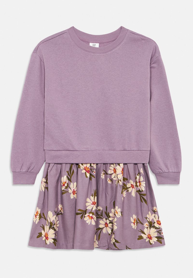 Lila långärmad klänning med en sweatshirt-aktig överdel och en blommönstrad kjol som har vita och röda blommor på en lavendelbakgrund.