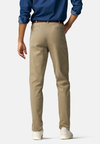 Beige chino's met een rechte pijp, gemaakt van katoen. De tailleband heeft een gevlochten bruine riem. Achterzakken zijn zichtbaar.