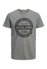 T-shirt in cotone grigio con grafica circolare nera contenente il testo "JACK & JONES" e diverse altre etichette, scollo rotondo, maniche corte.