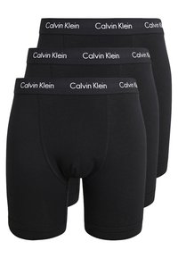 Crni pamučni bokserici u pakiranju od tri komada, s mekanim elastičnim pojasom na kojem je u bijeloj boji ispisan "Calvin Klein". Glatka tekstura i prilagođeni dizajn.