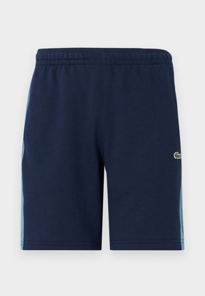 Pantaloni corti blu navy con un elastico in vita, con pannelli laterali in un blu più chiaro e un piccolo logo verde sulla gamba inferiore. Materiale in misto cotone.