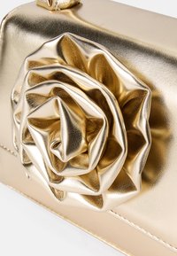 Clutch metallica dorata con dettaglio a forma di rosa 3D. Texture liscia, forma strutturata e cuciture decorative lungo il bordo. Design elegante e accattivante.