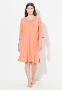 Różowa nocna koszula z dekoltem w serek oraz rękawami o długości trzech ćwierć, z subtelnymi kropkami w całym wzorze i zwiewną sylwetką w kształcie litery A.