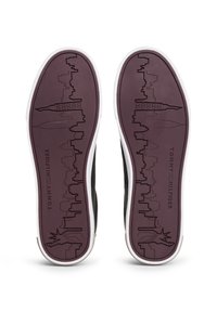 Schwarze Sneaker-Sohlen mit einer lila Unterseite, die eine Skyline und das Design der Freiheitsstatue zeigen; weiße Gummikanten und strukturierte Muster.