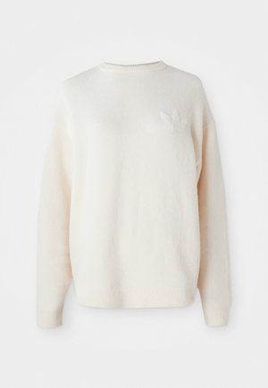 White, oversized fleece sweater with ribbed cuffs and hem. Features a small, tonal logo on the left chest. Soft texture and relaxed fit.