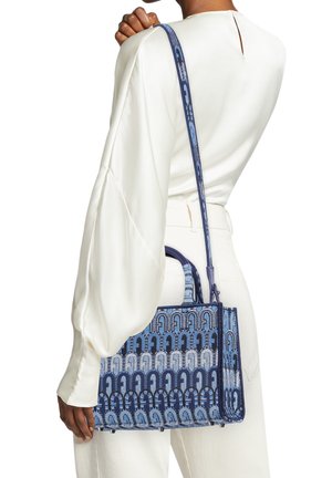 Modrý kabelka s vzorovaným designem, se strukturovaným tvarem, vybavená dvěma horními madly a dlouhým nastavitelným popruhem. Celkově texturovaný materiál.