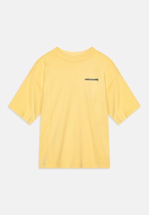 Geel katoenen T-shirt met een relaxed fit, korte mouwen en een zwart logo op de linkerkant van de borst. Zachte textuur, klassiek crewneck ontwerp.