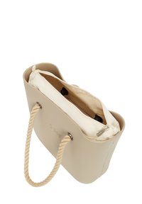Beige handtas met een gladde, rubberachtige buitenkant en een crèmekleurig interieur. Voorzien van touwhandvatten en een ritscompartiment binnenin.