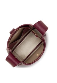 Sac à main rond avec un extérieur en cuir bordeaux texturé. À l'intérieur, il dispose d'une doublure beige et de deux compartiments séparés par une poche zippée.