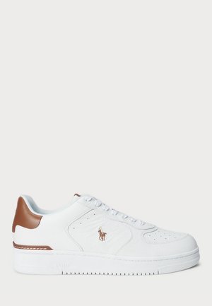 Biały niski sneaker z brązową łatą na pięcie, białymi sznurowadłami oraz małym brązowym logo gracza polo po boku, płaska biała podeszwa, widok z boku.