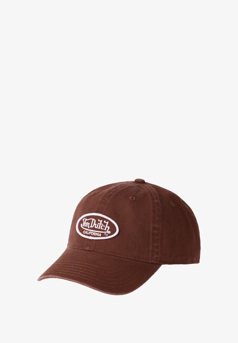 Casquette en coton marron avec un patch ovale blanc affichant "Von Dutch California." Elle est dotée d'un bord courbé et d'une sangle réglable à l'arrière.