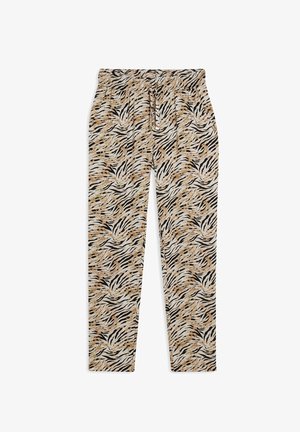 Pantalones ajustados con un patrón de estampado de tigre en negro, blanco y beige, con cintura elástica y cordón, sobre un fondo blanco.