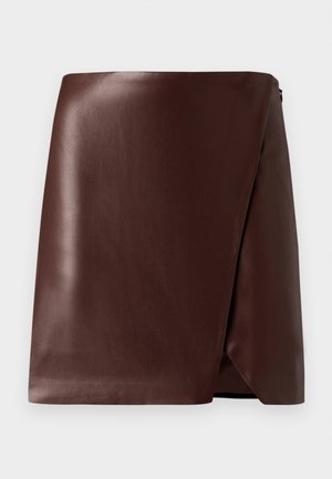 Hnedá kožená sukňa s hladkým povrchom, asymetrickým spodným okrajom a bočným zapínaním na zips. Minimalistický dizajn bez vzorov alebo akcentov.