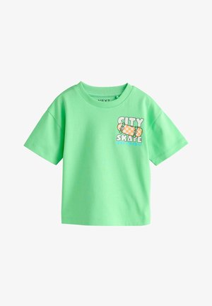 Kirkkaanvihreä lyhythihainen T-paita, jossa on teksti "CITY SKATE ROLL WITH IT" ja oranssi ruudullinen skeittilautagrafiikka rinnassa.