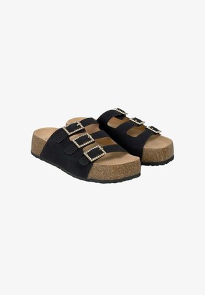 Sandali scivolosi in suede nero con tre fibbie ornamentali, plantare in sughero e suola in gomma testurizzata per una buona aderenza.