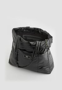 Czarna torba puffer z dwoma uchwytami, teksturowane wykończenie, kieszeń wewnętrzna na zamek błyskawiczny oraz zaciągany zamek w kolorze akcentującym.