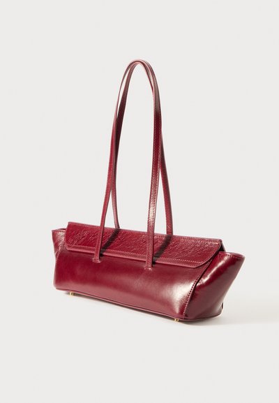 Μπορντό δερμάτινη τσάντα tote με δύο μακριές χειρολαβές, δομημένο σχέδιο και μυτερή βάση. Λείο υφή με μια διακριτική γυαλάδα.