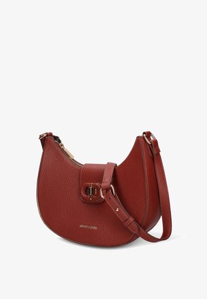 Red textured leather handbag with a curved shape, zip closure, and a buckle accent. Features an adjustable strap. Brand name printed on the front.
