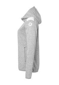 Grijze hoodie met een capuchon, ritszakken aan de zijkant en witte schouderaccenten. Beschikt over een logo op de linkerschouder en heeft een zachte textuur.