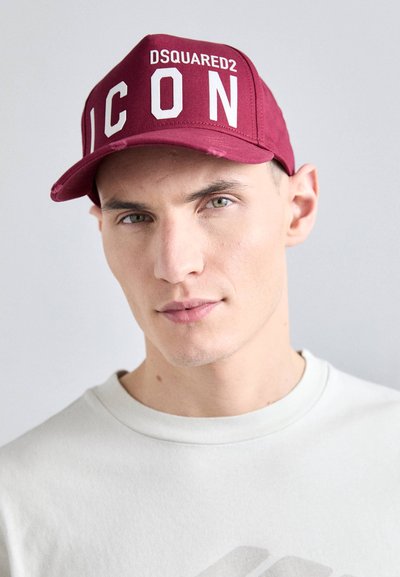 Casquette bordeaux avec inscription blanche "DSQUARED2 ICON", design structuré, visière incurvée et accents usés visibles. Tissu en coton, orientée vers l'avant.