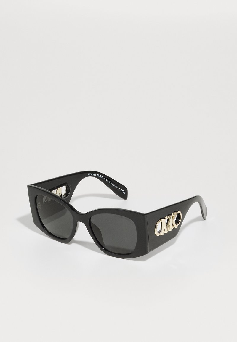 Μαύρα ορθογώνια γυαλιά ηλίου με σκούρους φακούς. Διαθέτουν γυαλιστερή επένδυση και χρυσές λεπτομέρειες στο πλάι που απεικονίζουν το λογότυπο της μάρκας.