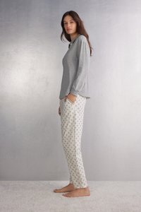 Lichtgrijs langmouwshirt met een ronde hals, gecombineerd met witte stretch pyjamabroek met een klein bloemmotief.