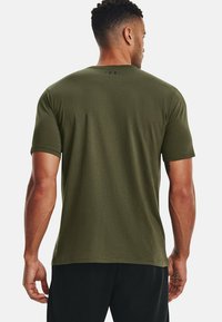 Ανοιχτοπράσινο T-shirt κοντό μανίκι φτιαγμένο από μείγμα βαμβακιού. Διαθέτει στρογγυλή λαιμόκοψη και ένα μικρό λογότυπο στην πλάτη, με υφή υφάσματος.