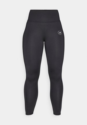 Mustat korkeavyötäröiset legginsit, jotka on valmistettu joustavasta kankaasta. Niissä on tiukka malli ja pieni valkoinen logo vasemmalla lantion kohdalla.