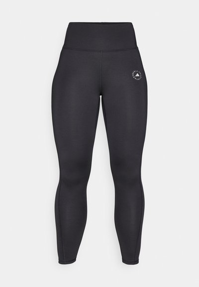 Černé legíny s vysokým pasem vyrobené z elastické tkaniny, s přiléhavým střihem a malým bílým logem na levém boku.