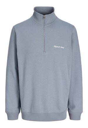 Maglione azzurro chiaro a maniche lunghe con mezza cerniera e collo alto, con una piccola scritta bianca "Originals Studio" sul lato sinistro del petto.