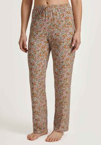 Bloemige katoenen pyjamabroek met een trekkoord in de taille; voorzien van een herhalend patroon van roze en oranje bloemen op een beige achtergrond.