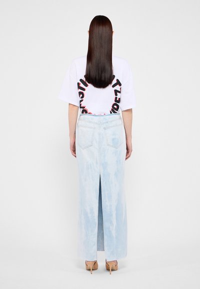 Lyse blå denimlang skjørt med slisse bak, har to baklommer. Sammen med en hvit oversized t-skjorte med grafisk trykk.