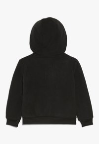 Svart huvtröja med ett mjukt, texturerat tyg. Har en rundad huva och ribbad mudd vid ärmarna och midjan. Bakifrån visad.