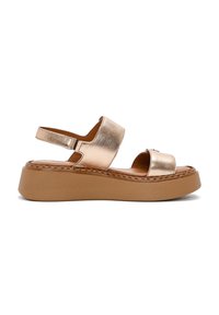 Sandali platform metallici di bronzo con due ampie cinghie e una cinghia alla caviglia, caratterizzati da una suola marrone texturizzata e dettagli cuciti.